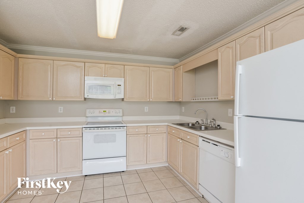 a kitchen with white appliances and wooden cabinets