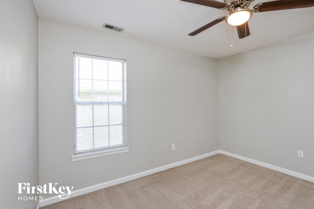 a living room with a ceiling fan and a window
