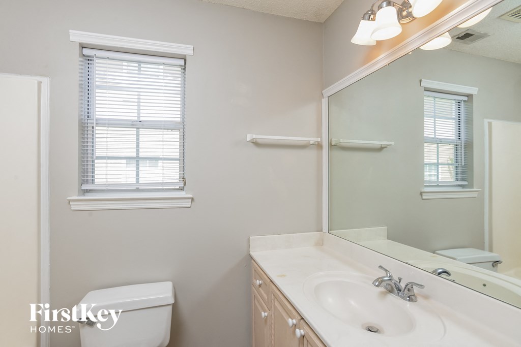 a bathroom with a mirror and a sink and a toilet