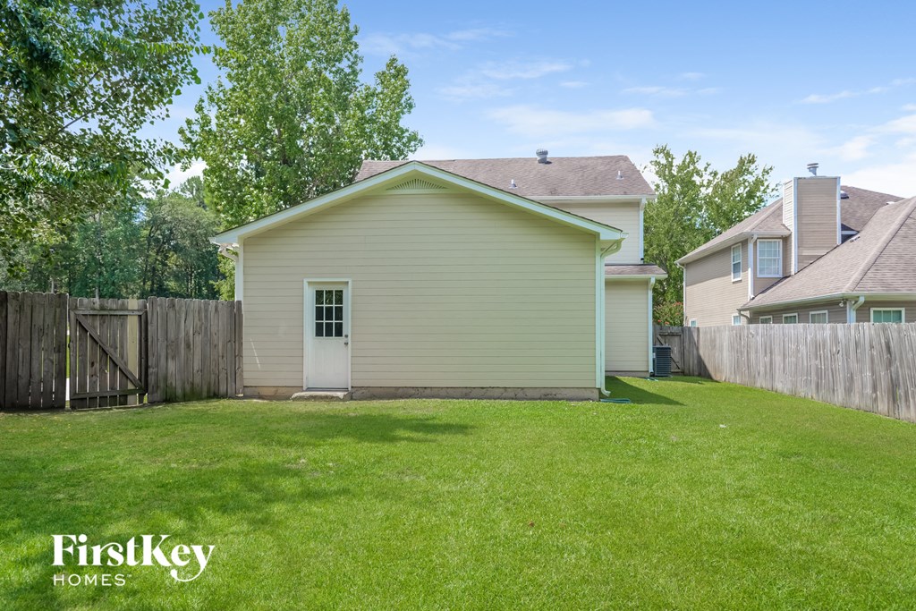 the backyard of a house with a yard and a fence