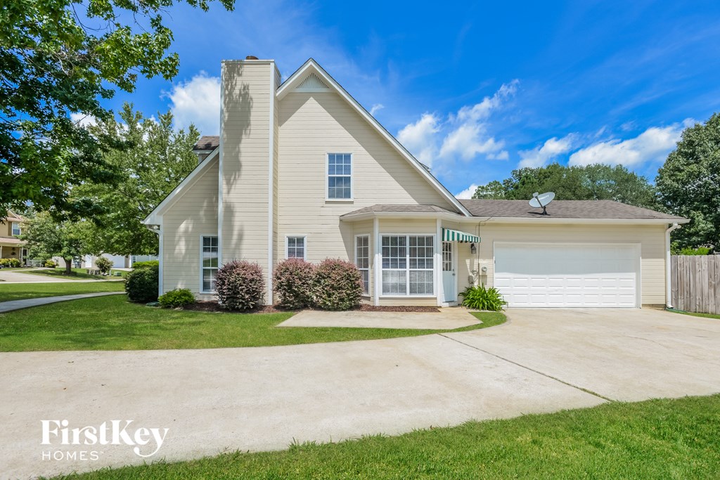 a white house with a driveway and a garage door