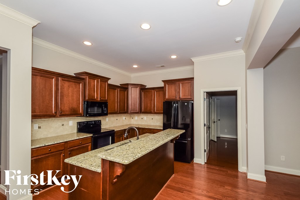 a kitchen with wood cabinets and granite counter tops and black appliances