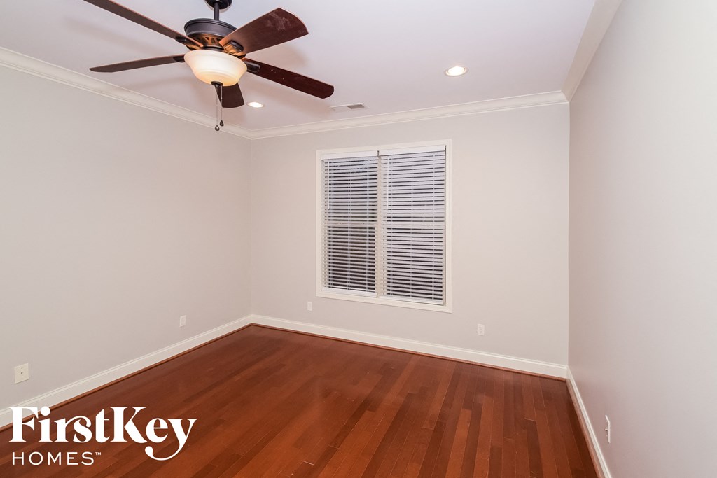 a bedroom with hardwood flooring and a ceiling fan
