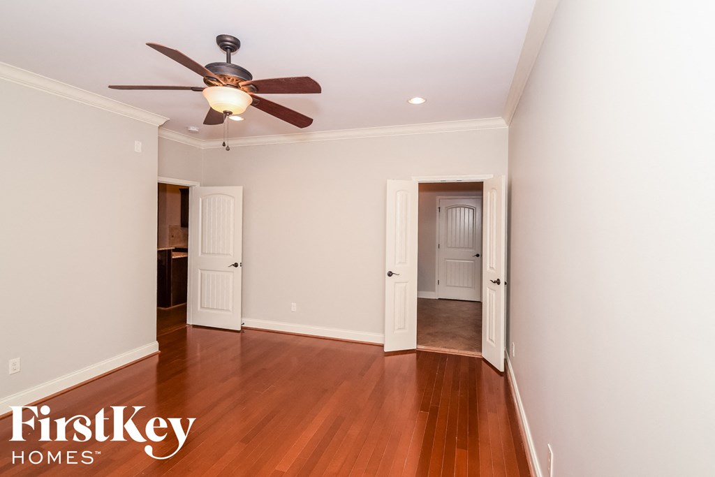 a living room with wood floors and a ceiling fan