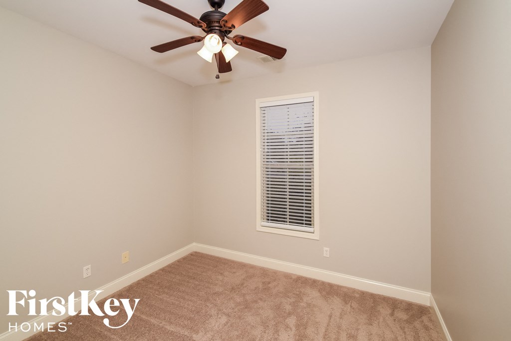 a empty room with a ceiling fan and a window