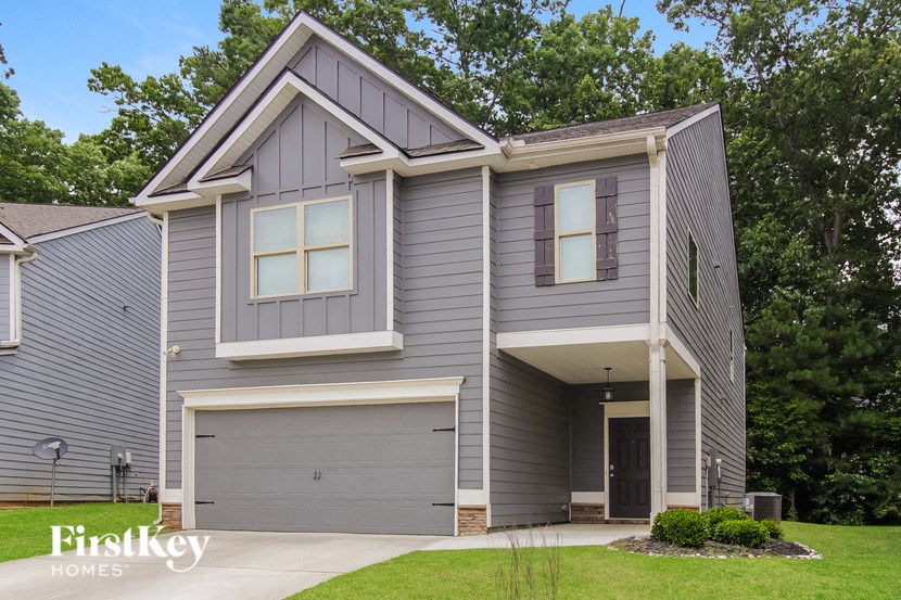 A grey house with a garage door and a window.