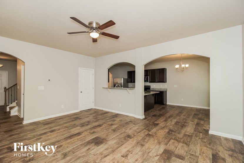 A spacious room with a ceiling fan and wooden flooring.