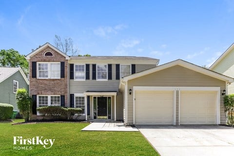 a house with a garage door and a lawn