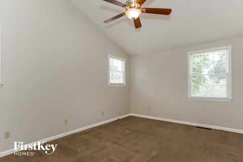 the living room of a home with a carpet and a ceiling fan