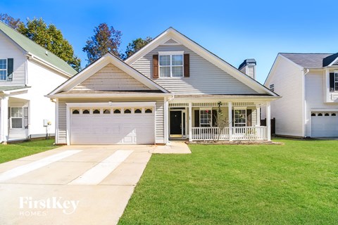 a white house with a lawn and a white garage door