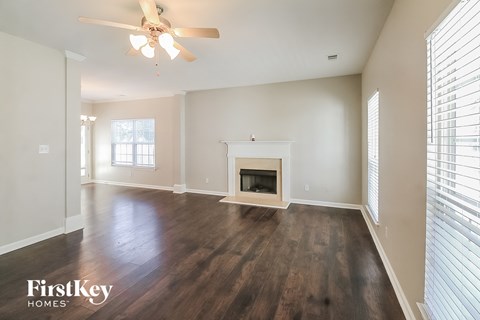 a living room with a fireplace and a ceiling fan