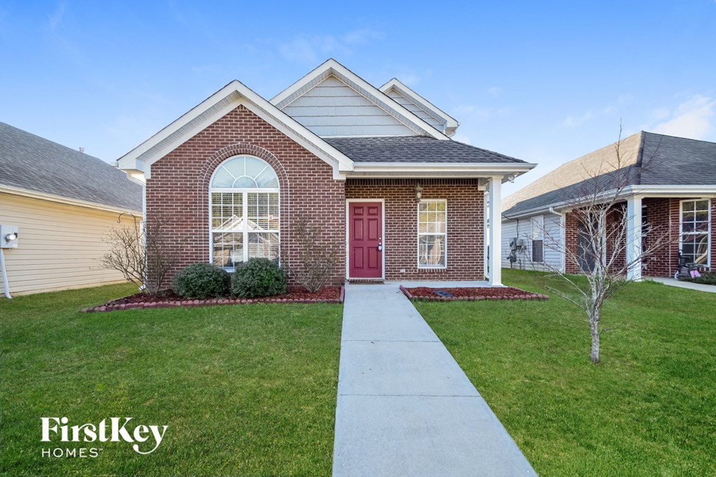 a home with a red door and a sidewalk in front of it