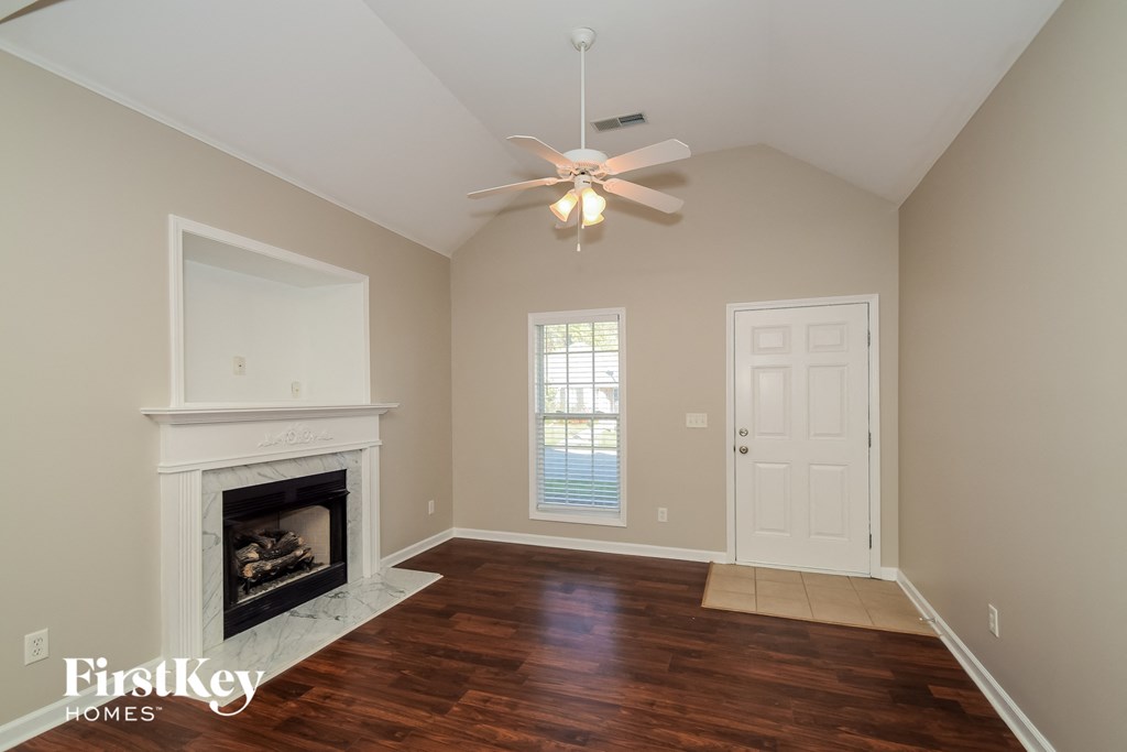 a living room with a fireplace and a ceiling fan