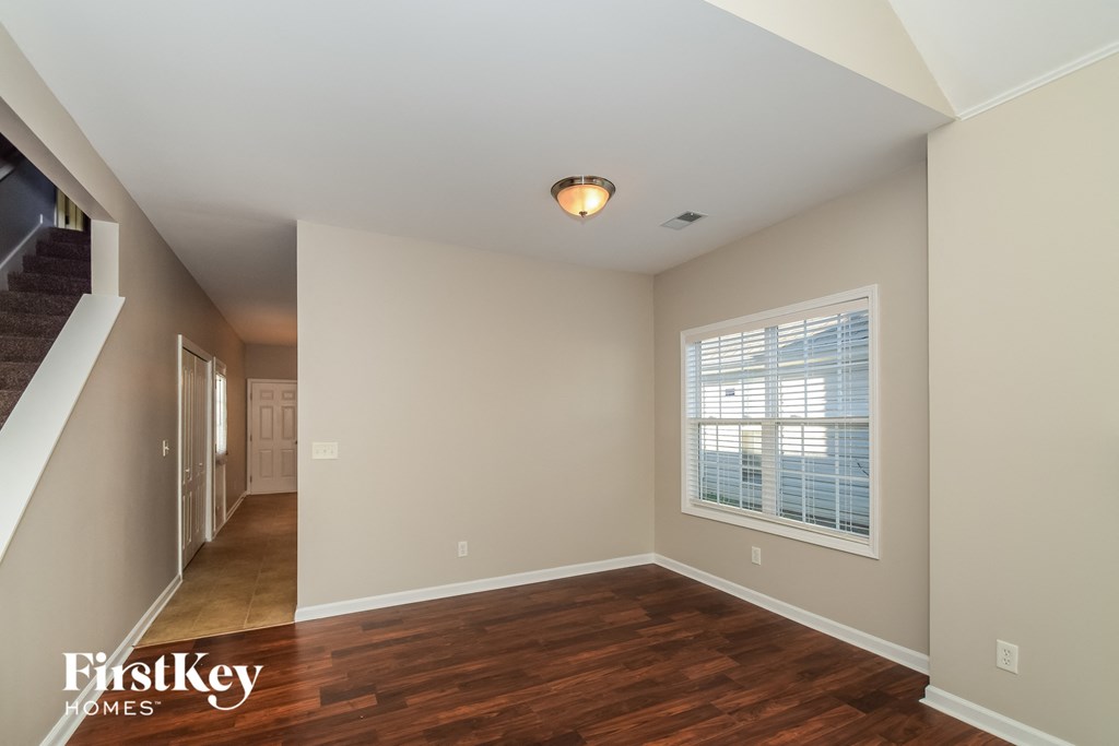 an empty living room with wood floors and a large window