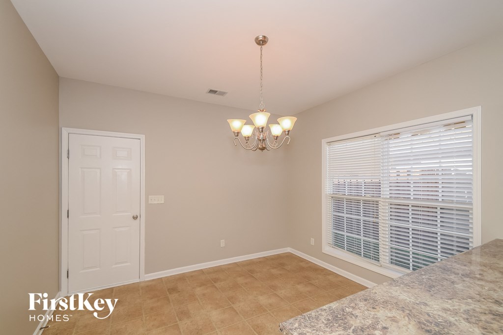a kitchen and dining room with a large window and a chandelier