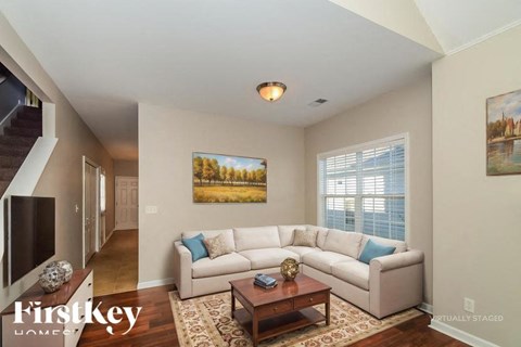 A living room with a couch, coffee table, and a painting on the wall.