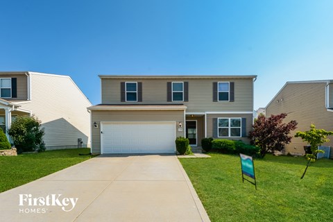a house with a garage door and a lawn