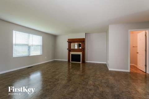 an empty living room with a fireplace and a window