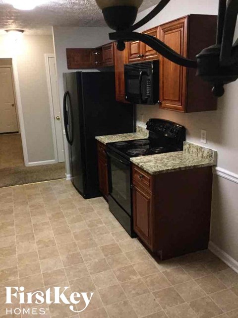 a kitchen with a black stove and a refrigerator
