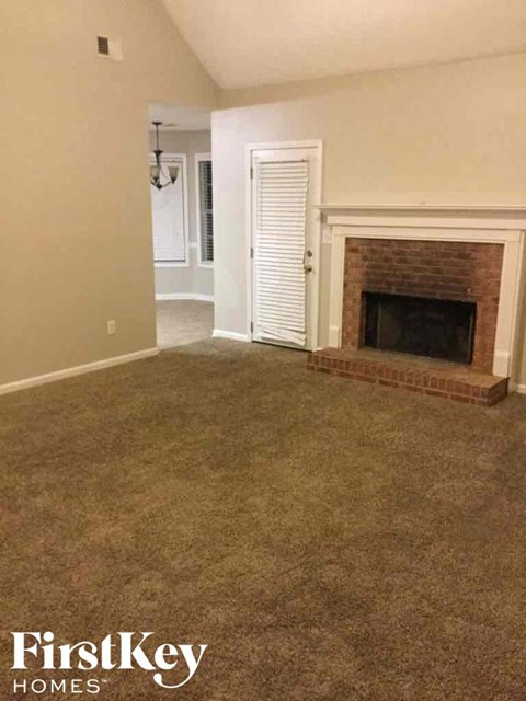 a living room with a carpeted floor and a fireplace