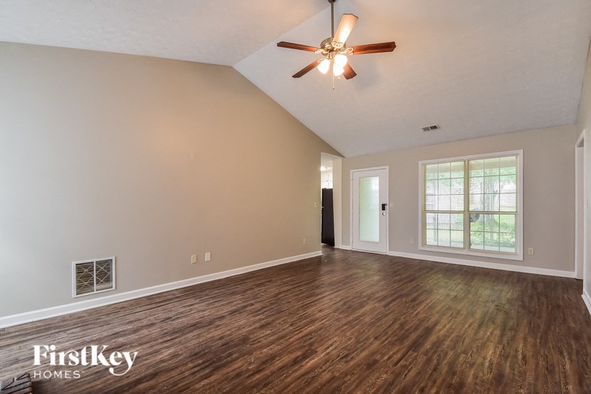 the living room of an empty house with a ceiling fan