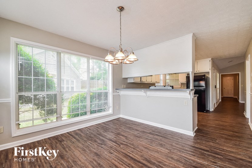 an empty living room and kitchen with a large window
