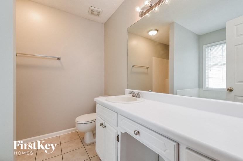a bathroom with a large mirror and a sink and a toilet