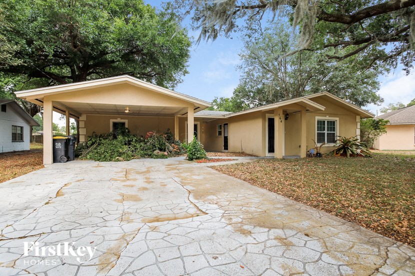 A house with a stone driveway in front of it.