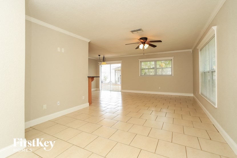 A spacious room with a fan and tile flooring.