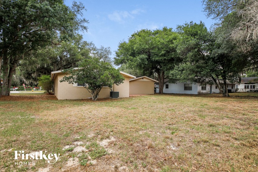 A house with a lawn and trees in front of it.