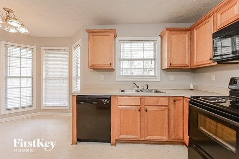 a kitchen with wooden cabinets and black appliances