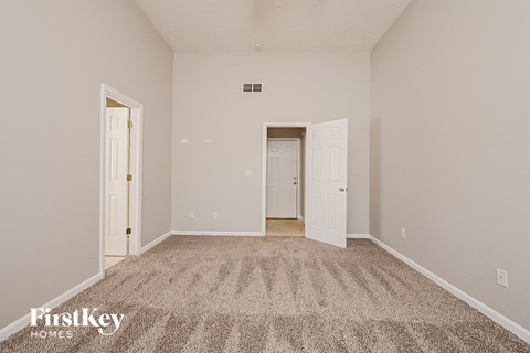 a spacious living room with carpet and white doors