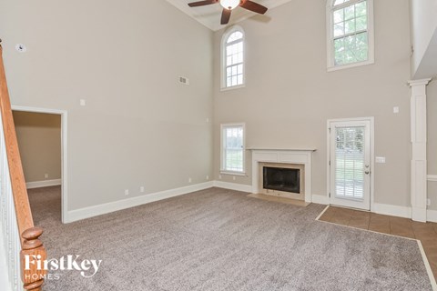 A spacious room with a fireplace and a ceiling fan.