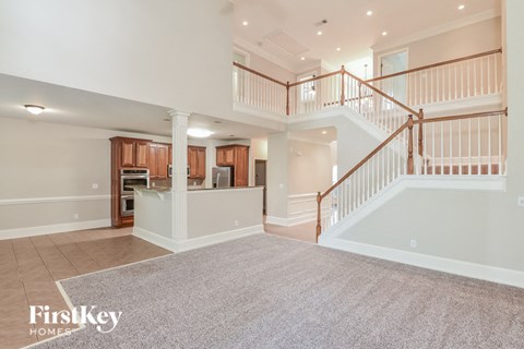 A spacious living area with a staircase leading to the upper floor.