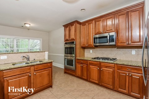 A kitchen with wooden cabinets and a granite countertop.