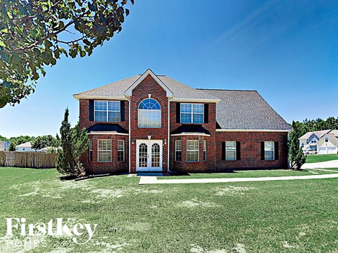 a large brick house with a lawn in front of it