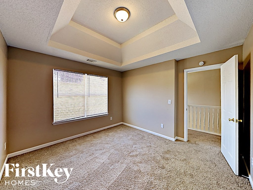 an empty living room with a large window and a door to a closet