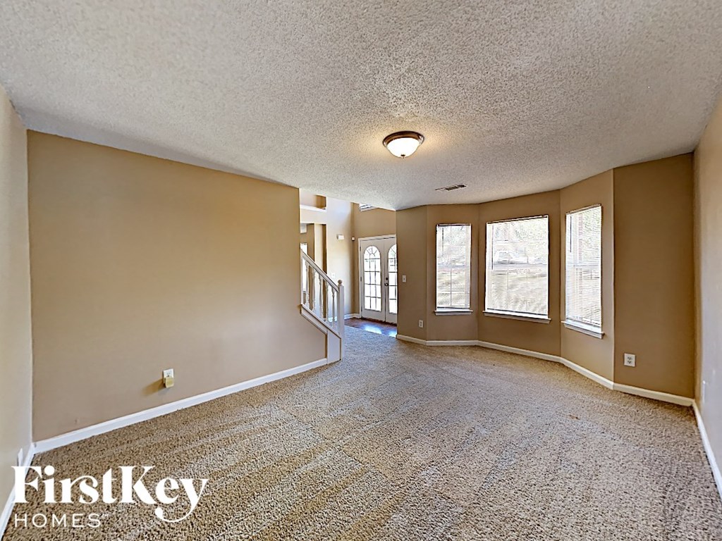 the living room and dining room of an empty house