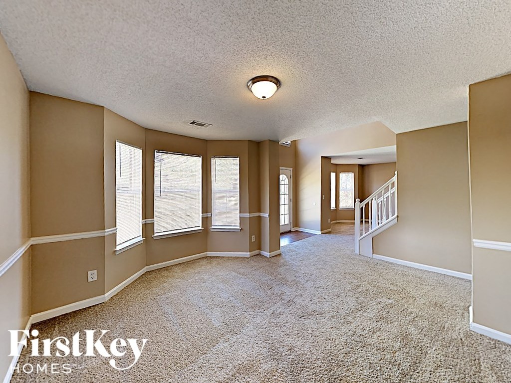 the living room and dining room of an empty house with windows