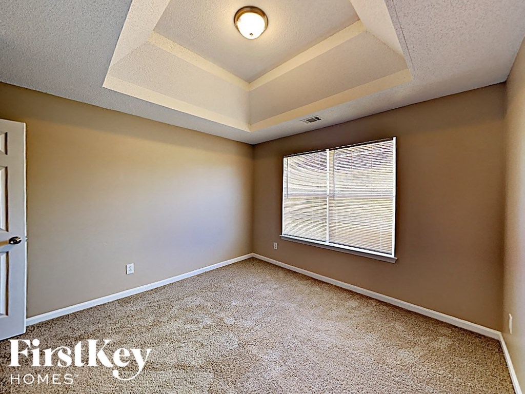 an empty bedroom with a large window and a white ceiling