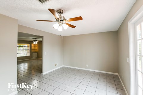 A room with a ceiling fan and tile flooring.