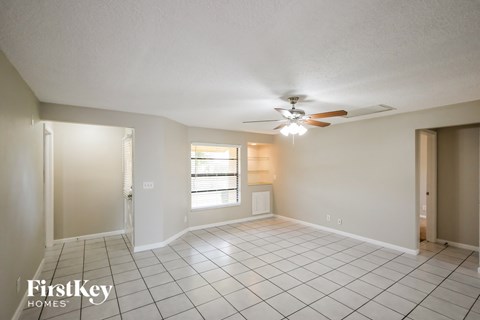 A spacious room with a ceiling fan and tiled flooring.