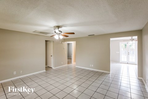 A spacious room with a fan and tile flooring.