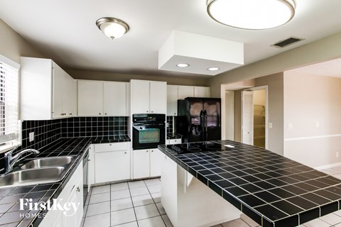A modern kitchen with black and white tiles.