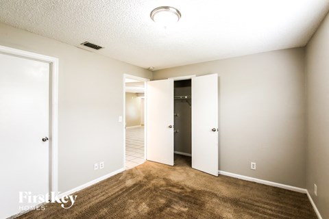 A room with a carpeted floor and a doorway leading to another room.