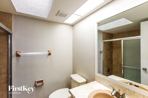 A bathroom with a toilet, sink, and shower.