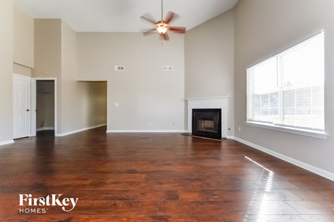 A spacious living room with a fireplace and wood flooring.