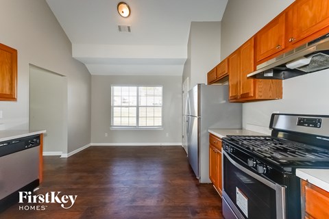 A kitchen with wooden cabinets and a stainless steel refrigerator.