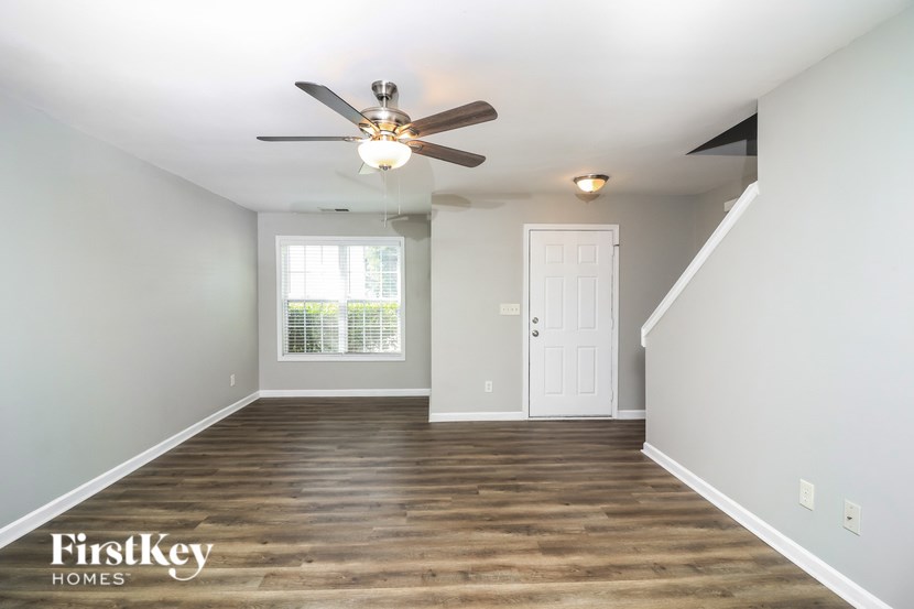 A room with a ceiling fan and wooden flooring.