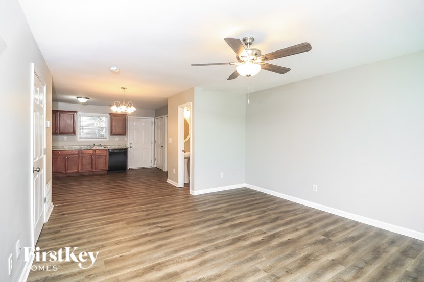 A spacious room with a ceiling fan and wooden flooring.